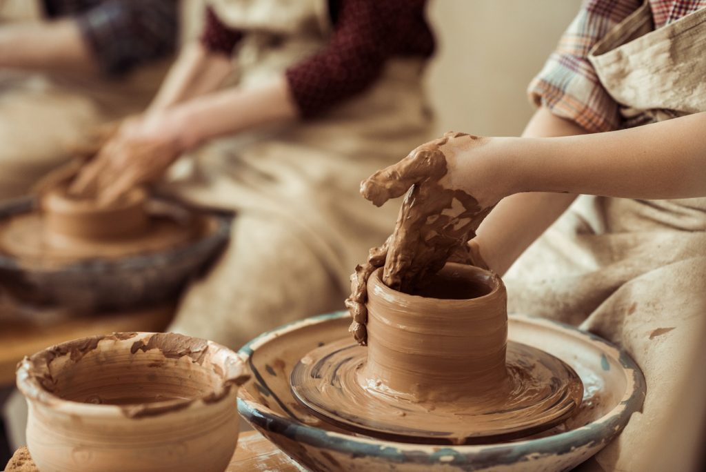 Close up of child hands working on pottery wheel at workshop